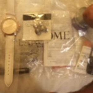 Watch,makeup, face cream, earrings by lancome